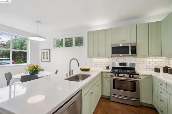 a kitchen with stainless steel appliances a sink stove and refrigerator