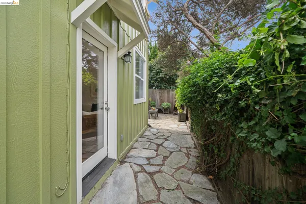 a backyard of a house with lawn chairs and a barbeque