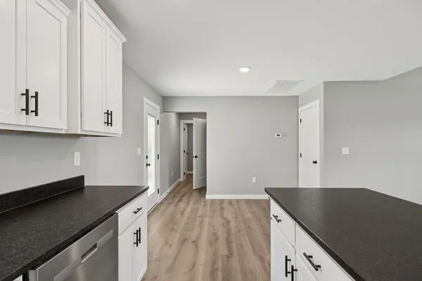 a view of a kitchen with a dishwasher wooden floor and a kitchen