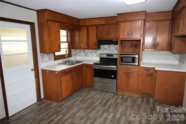 a kitchen with stainless steel appliances granite countertop a stove a sink and a refrigerator