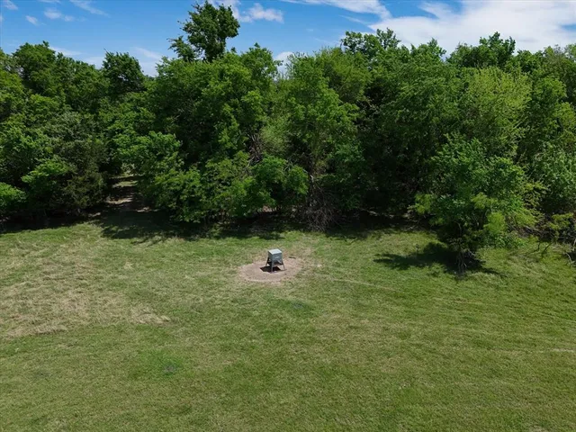 a view of a green field with trees in the background