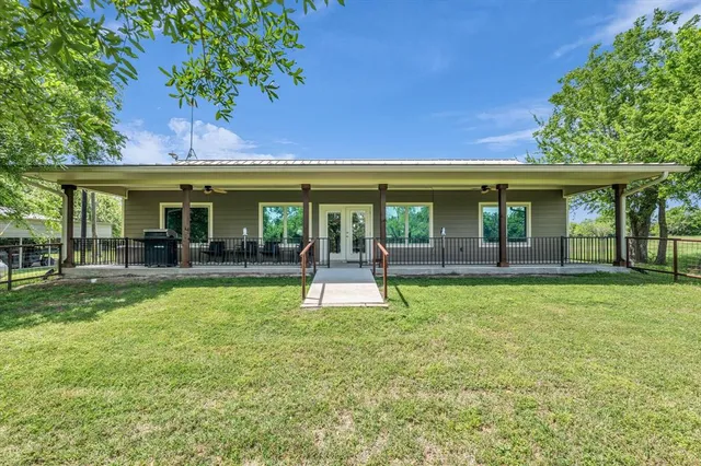 a view of house with a backyard space and balcony