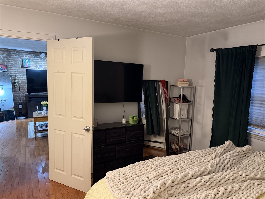 32 Fleet Street, Unit B Boston, MA 02113 - Photo 5 of 7 a bedroom with a bed and a television