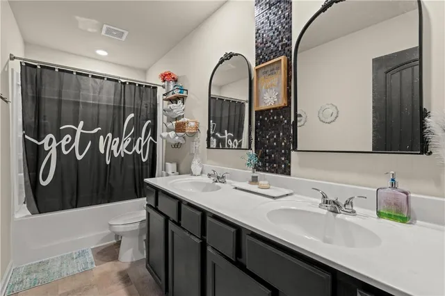 a bathroom with a sink a toilet and a mirror