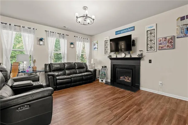 a living room with furniture a flat screen tv and a fireplace