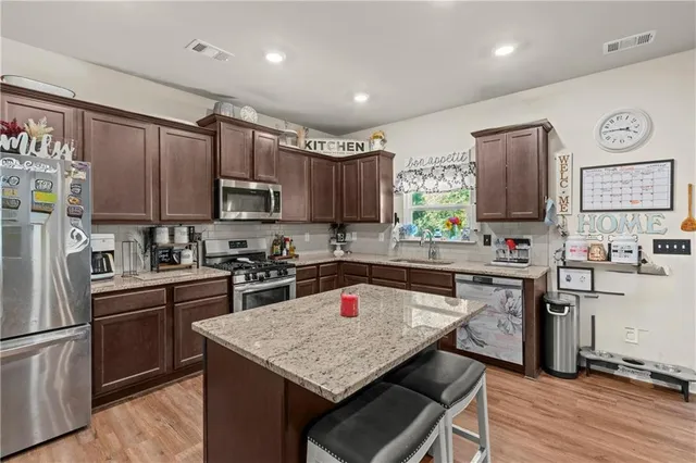 a kitchen with stainless steel appliances granite countertop a refrigerator stove microwave and sink
