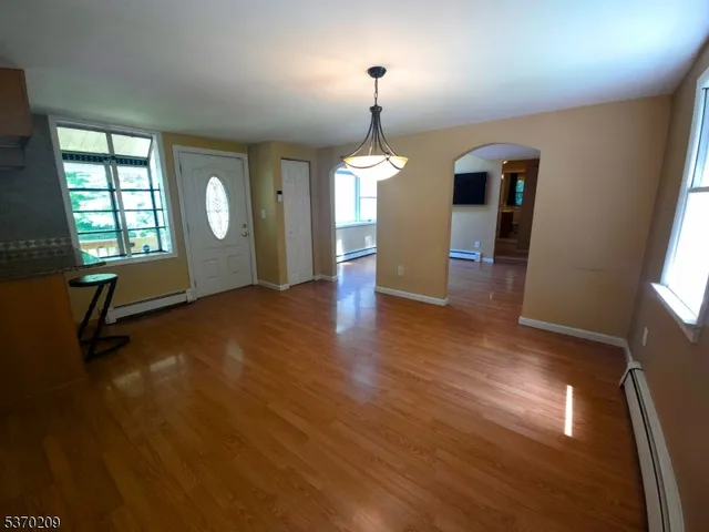 a view of a room with wooden floor fireplace and windows