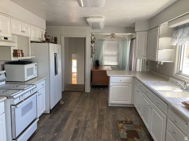 200 South 2800th Street West Ogden, UT 84404 - Photo 5 of 42 Kitchen featuring white appliances, white cabinets, light countertops, a peninsula, and dark wood-style flooring