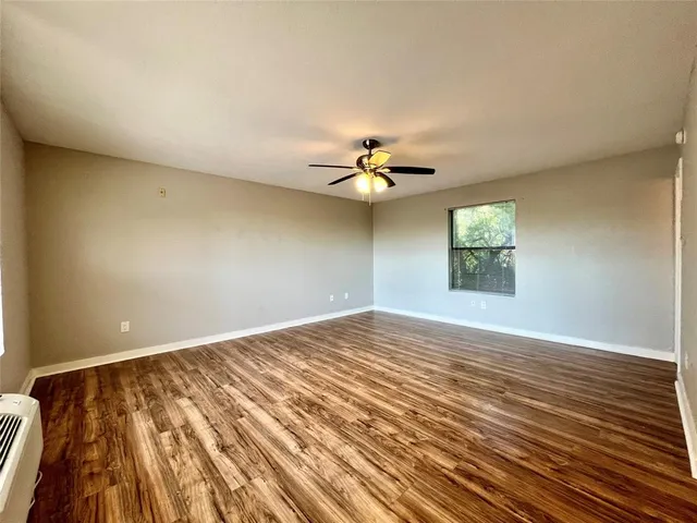 a view of an empty room and chandelier fan
