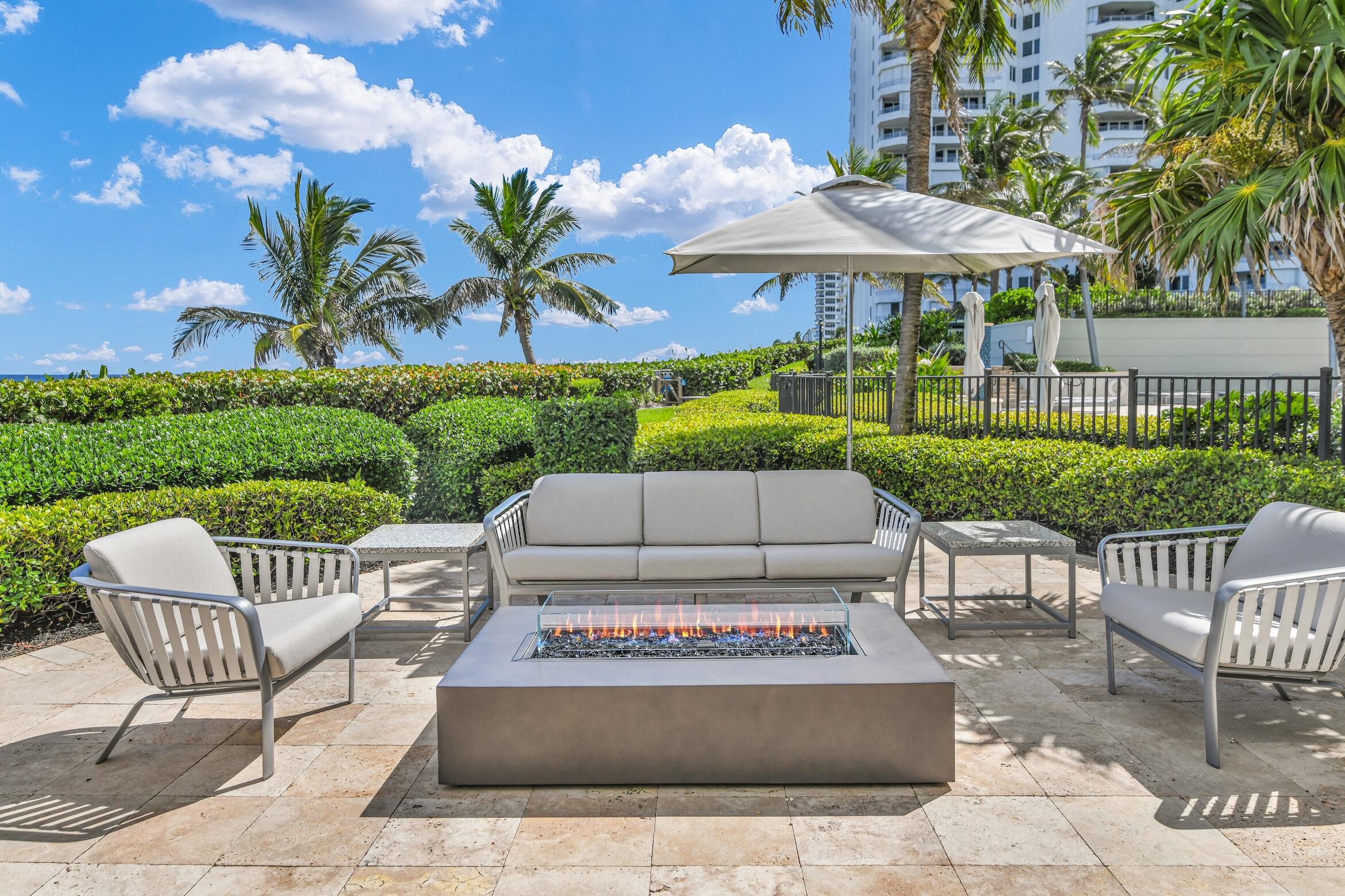 500 South Ocean Boulevard, Unit 803 Boca Raton, FL 33432 - Photo 21 of 72 a view of a patio with a table and chairs under an umbrella