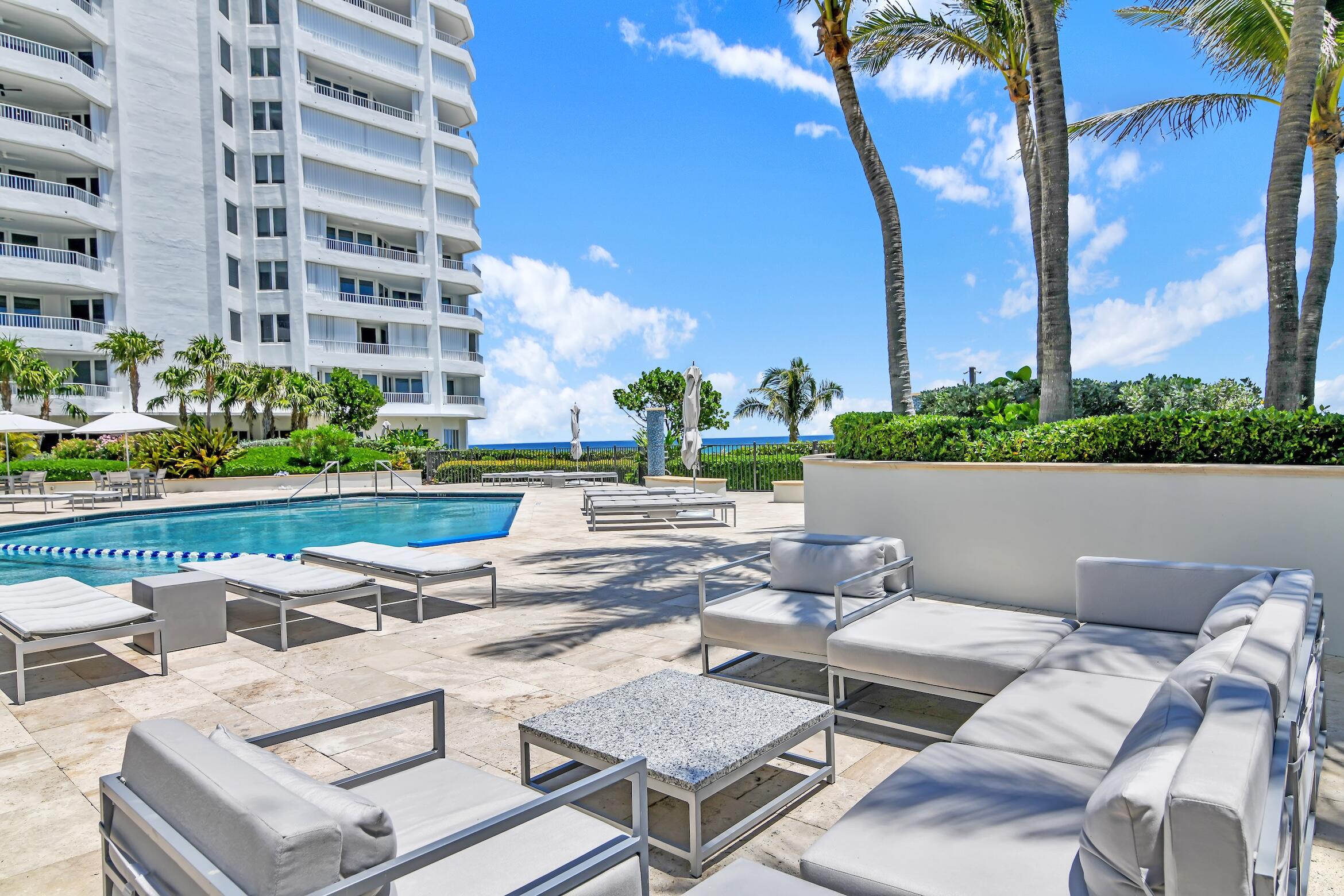 500 South Ocean Boulevard, Unit 803 Boca Raton, FL 33432 - Photo 25 of 72 a view of a patio with couches table and chairs with potted plants and a palm tree