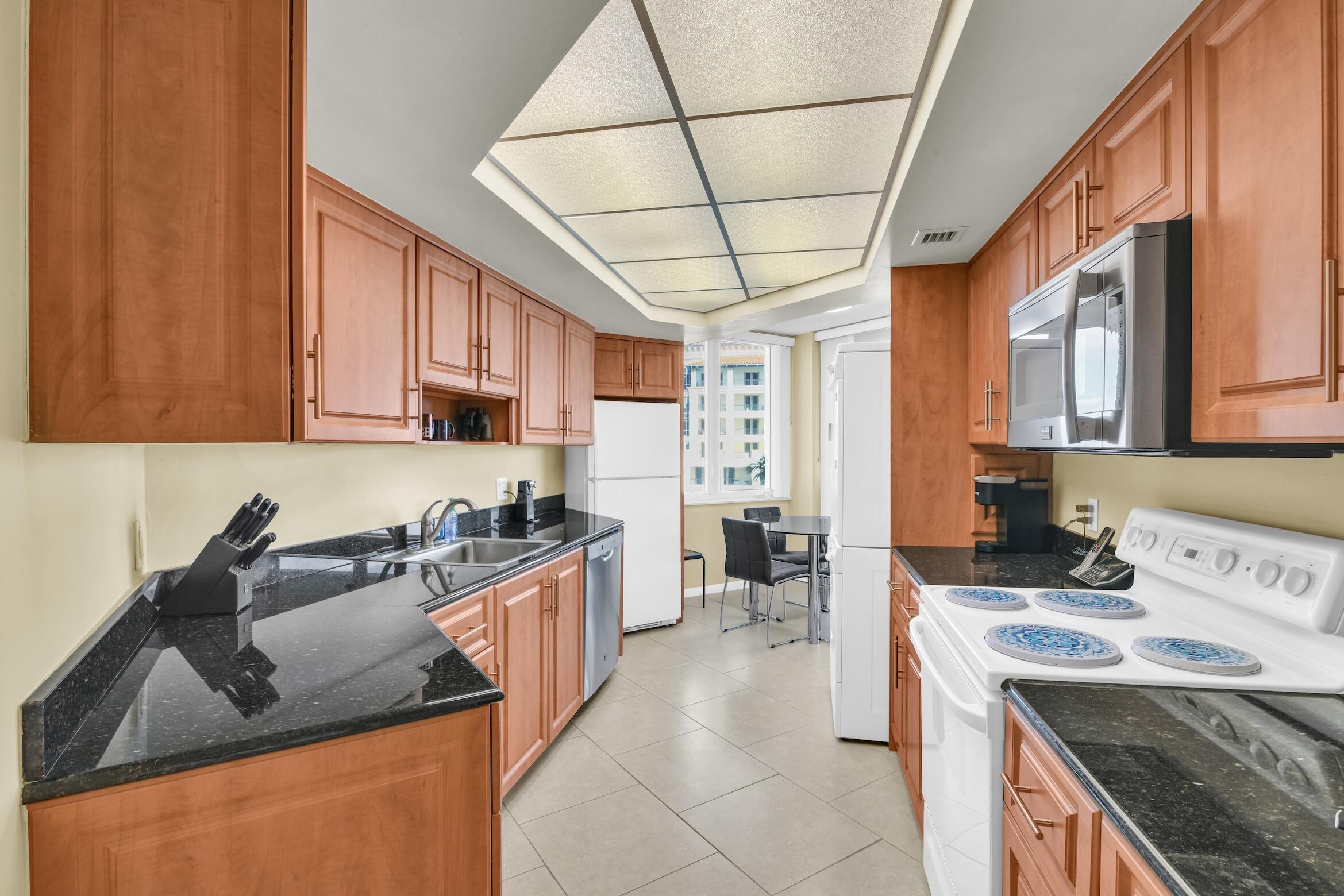 500 South Ocean Boulevard, Unit 803 Boca Raton, FL 33432 - Photo 10 of 72 a kitchen with stainless steel appliances granite countertop a sink stove and refrigerator