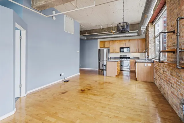 a view of a kitchen with a sink stainless steel appliances furniture and a window