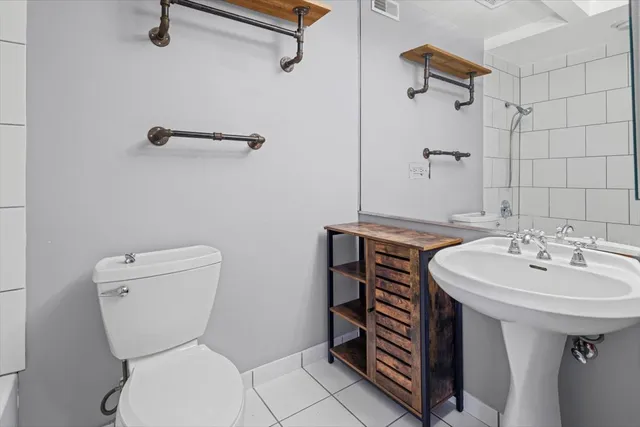 a bathroom with a sink a toilet and a mirror