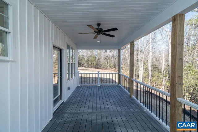a view of a room with wooden floor a ceiling fan and windows