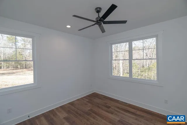 a view of a big room with wooden floor and windows