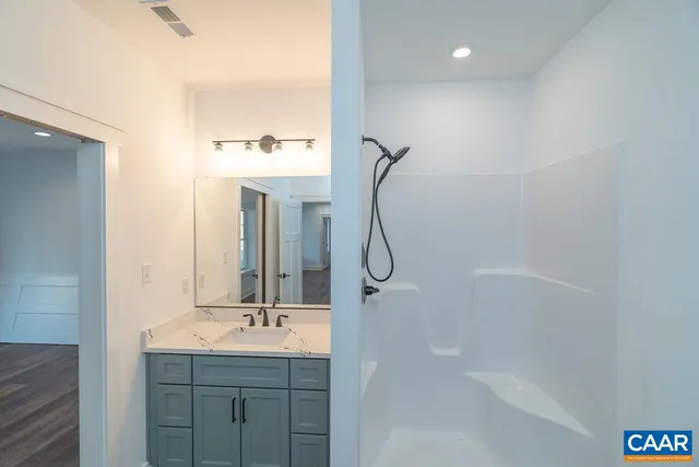 a bathroom with a sink a mirror and shower