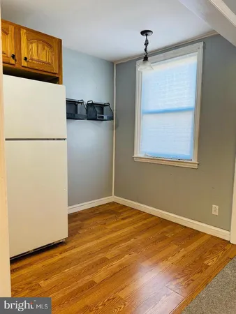 a view of a refrigerator in an empty room