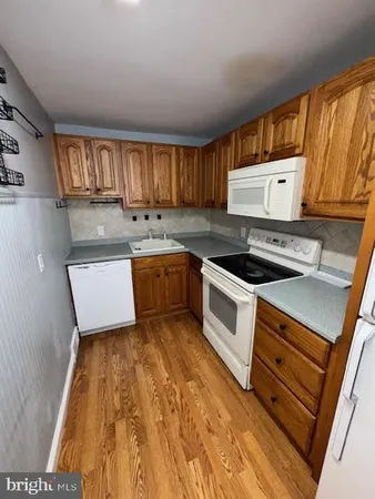 a kitchen with wooden cabinets and white appliances