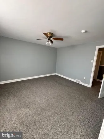 an empty room with a ceiling fan and window
