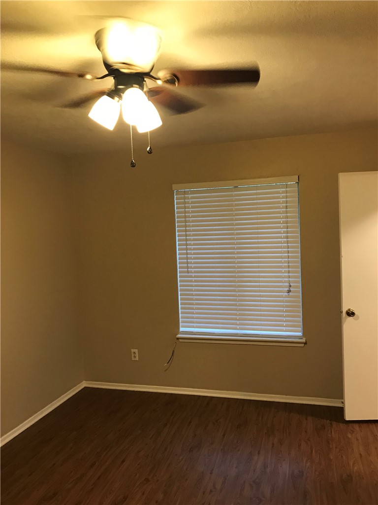 3201 Cougar Trail, Unit A Bryan, TX 77807 - Photo 6 of 15 a view of an empty room with wooden floor and a window