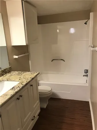 a bathroom with a granite countertop sink toilet and shower