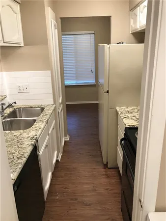 a kitchen with a refrigerator sink and cabinets
