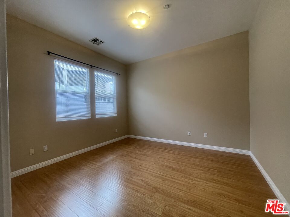 904 East Windsor Road, Unit 103 Glendale, CA 91205 - Photo 21 of 26 a view of an empty room with wooden floor and a window