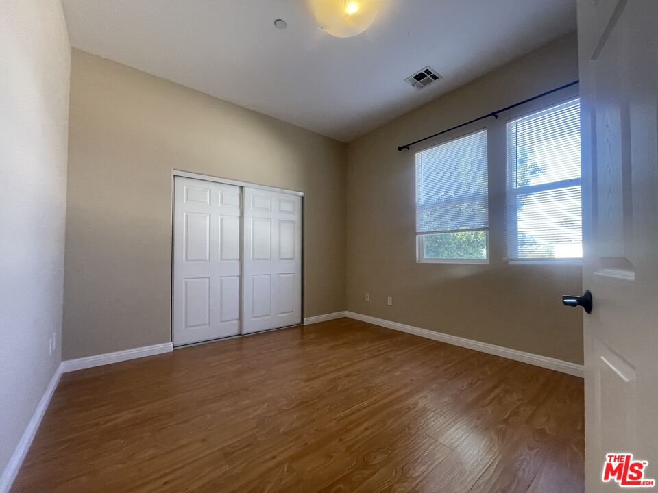 904 East Windsor Road, Unit 103 Glendale, CA 91205 - Photo 22 of 26 a view of an empty room with wooden floor and a window