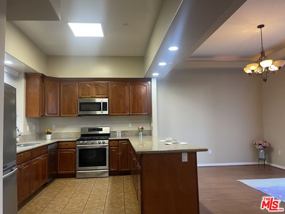 904 East Windsor Road, Unit 103 Glendale, CA 91205 - Photo 6 of 26 a kitchen with stainless steel appliances granite countertop a stove a sink dishwasher a refrigerator and a microwave oven