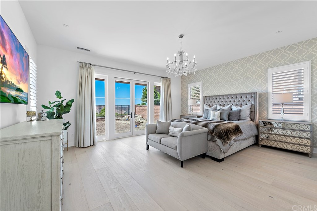 9 Catalina Vista Road Ladera Ranch, CA 92694 - Photo 13 of 41 a spacious bedroom with a bed and a chandelier