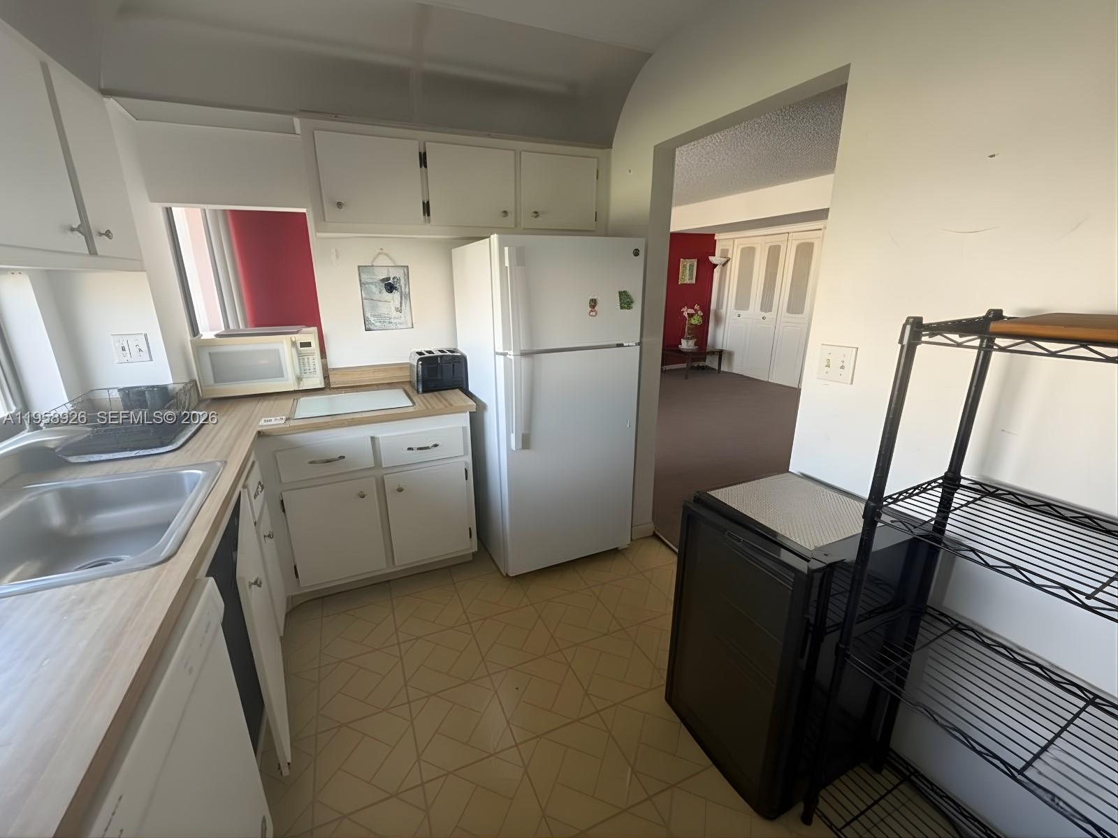 17021 North Bay Road, Unit 706 Sunny Isles Beach, FL 33160 - Photo 3 of 14 a kitchen with a refrigerator sink stove and cabinets