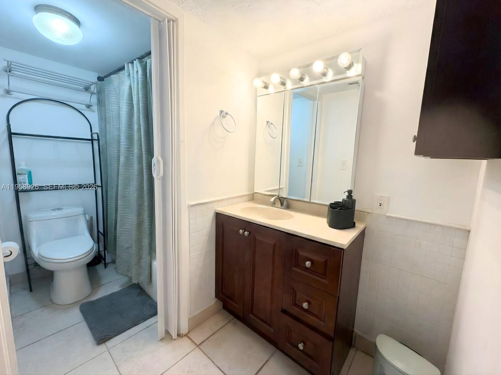 17021 North Bay Road, Unit 706 Sunny Isles Beach, FL 33160 - Photo 7 of 14 a bathroom with a toilet a sink and mirror
