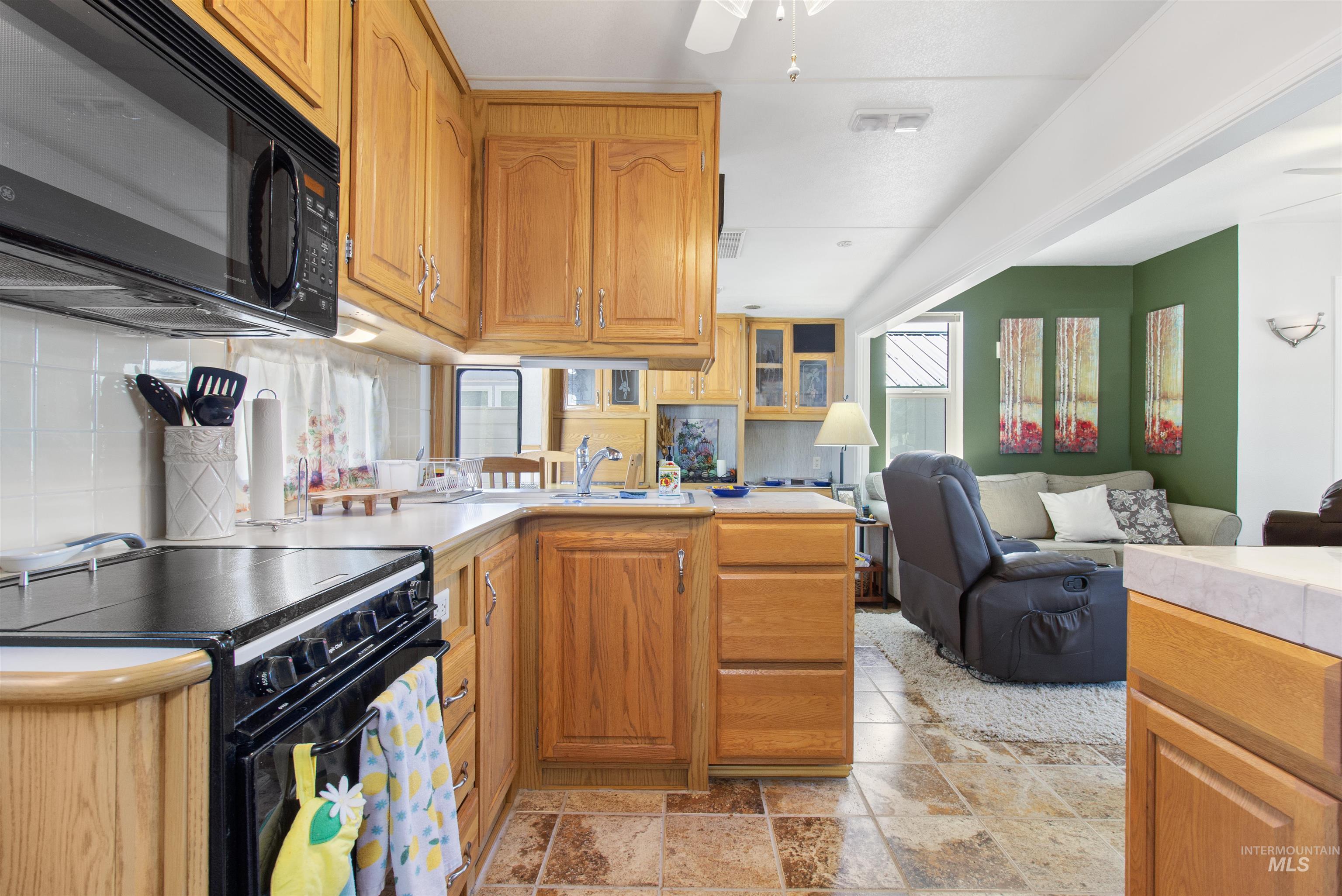 106 West Magic Road Shoshone, ID 83352 - Photo 19 of 45 Kitchen featuring wood cabinetry, solid surface countertops, tile flooring, and a stainless steel sink with a gooseneck faucet