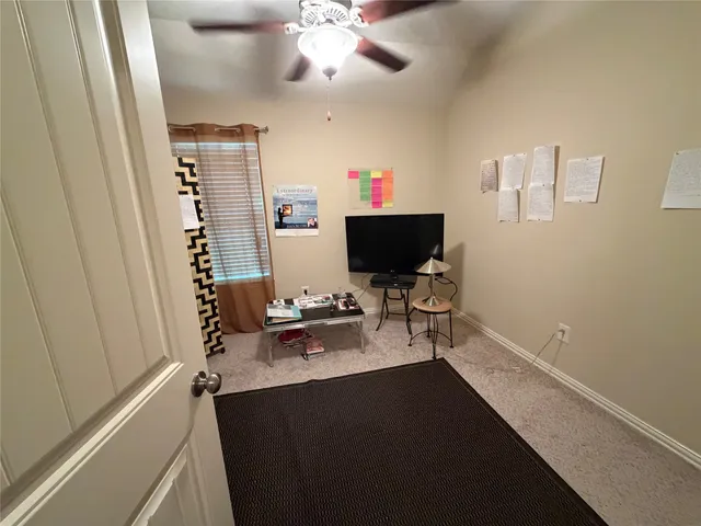 a view of a workspace with furniture and a window