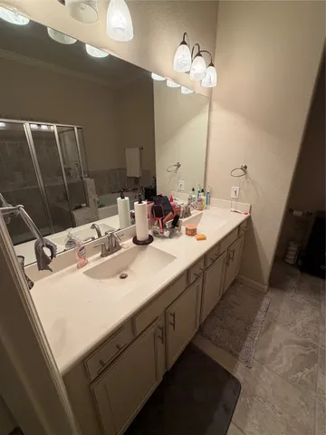 a bathroom with double vanity and a mirror
