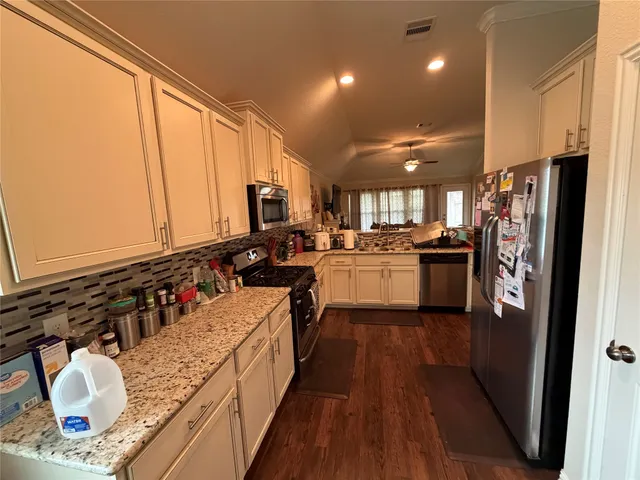 a kitchen with stainless steel appliances granite countertop a sink stove and refrigerator