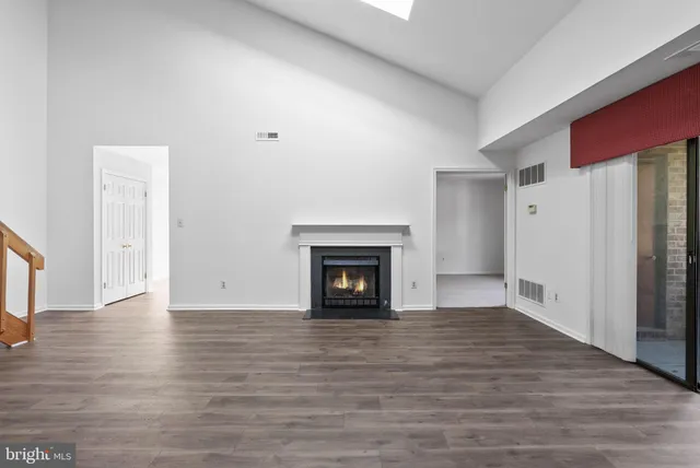 a view of a livingroom with wooden floor and a fireplace