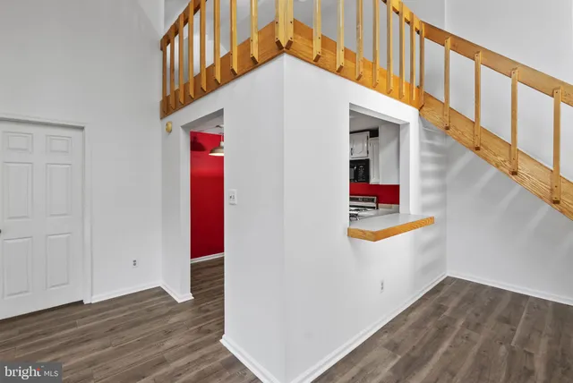a view of a hallway with wooden floor and staircase