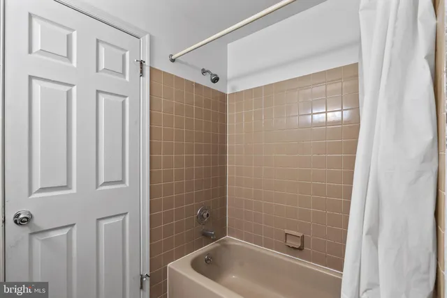 a bathroom with a tub shower and vanity