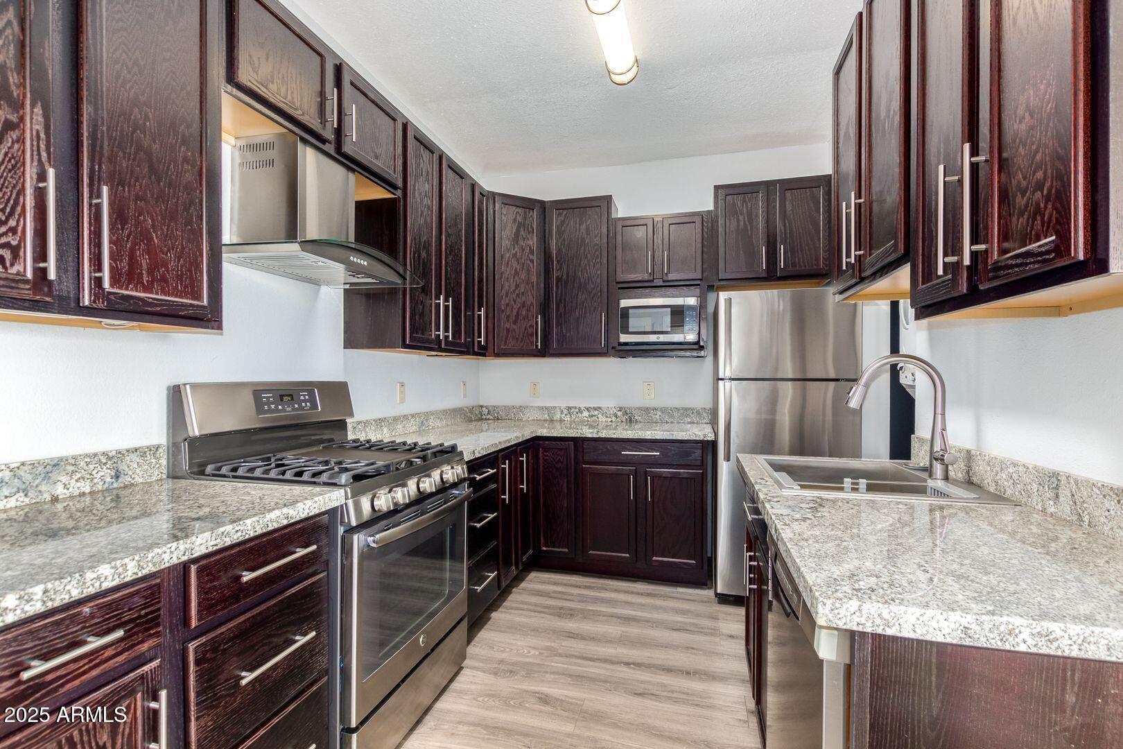 822 North 7th Street, Unit 2 Phoenix, AZ 85004 - Photo 1 of 18 a kitchen with stainless steel appliances granite countertop a stove top oven a sink and dishwasher