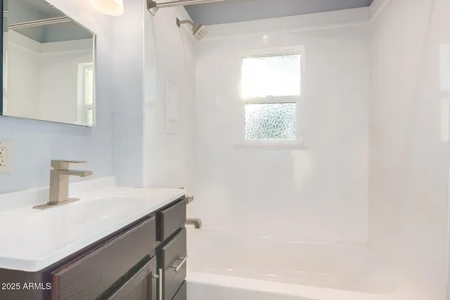 a bathroom with a sink a vanity and a bathtub