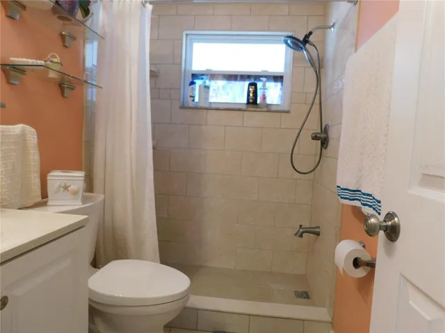 a bathroom with a granite countertop sink mirror vanity and toilet