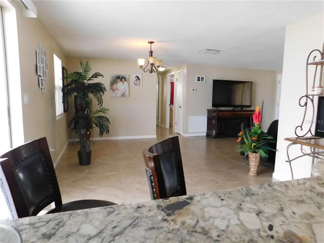 a living room with furniture a chandelier and a flat screen tv