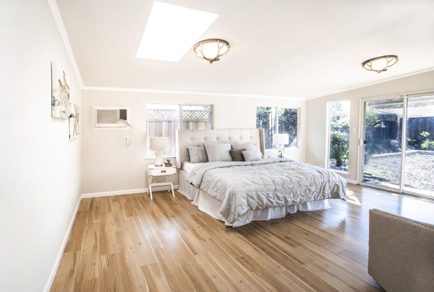 4447 Sloat Road Fremont, CA 94538 - Photo 23 of 28 a spacious bedroom with a bed and wooden floor