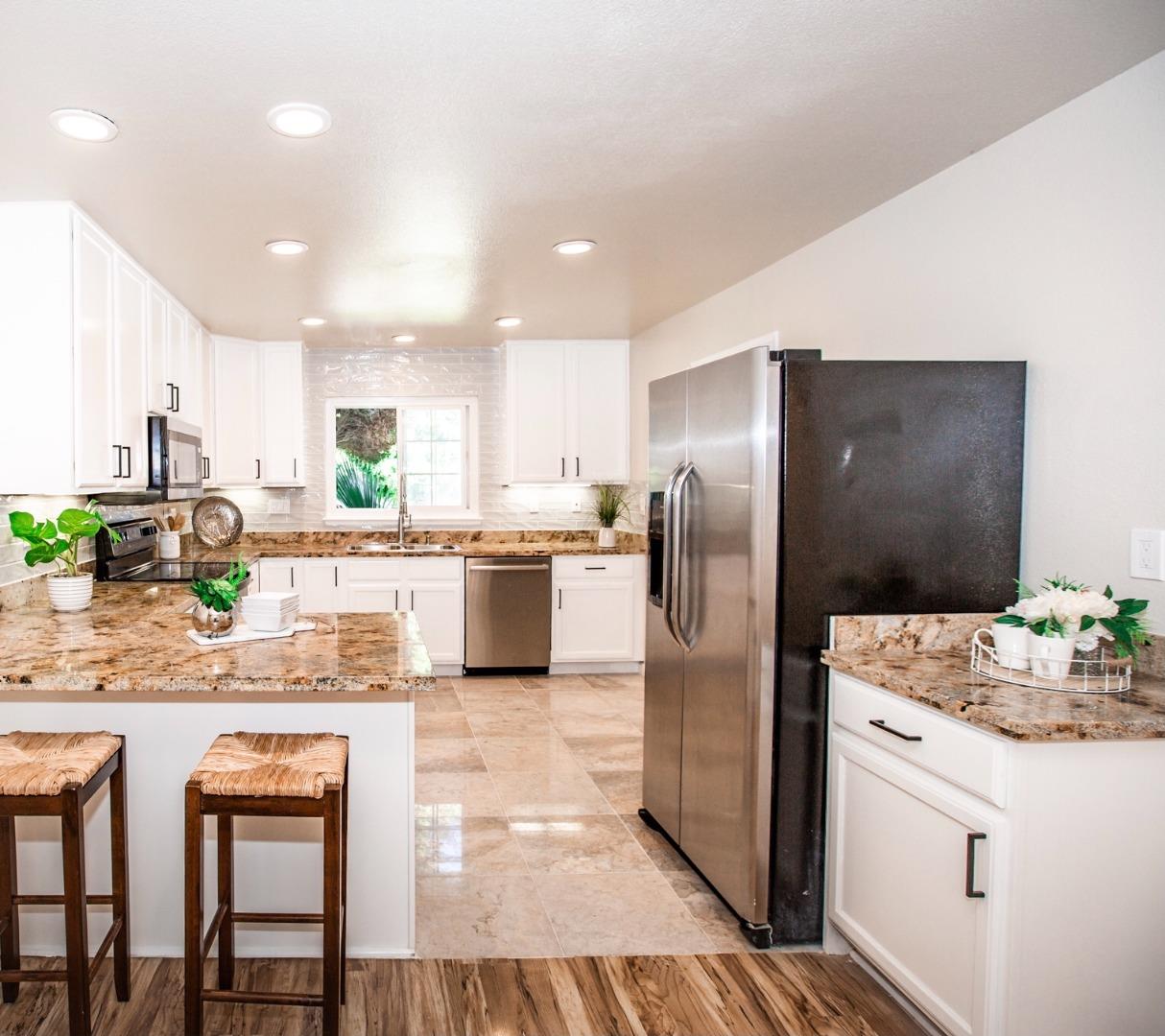 4447 Sloat Road Fremont, CA 94538 - Photo 6 of 28 a kitchen with stainless steel appliances kitchen island granite countertop a refrigerator and a stove top oven