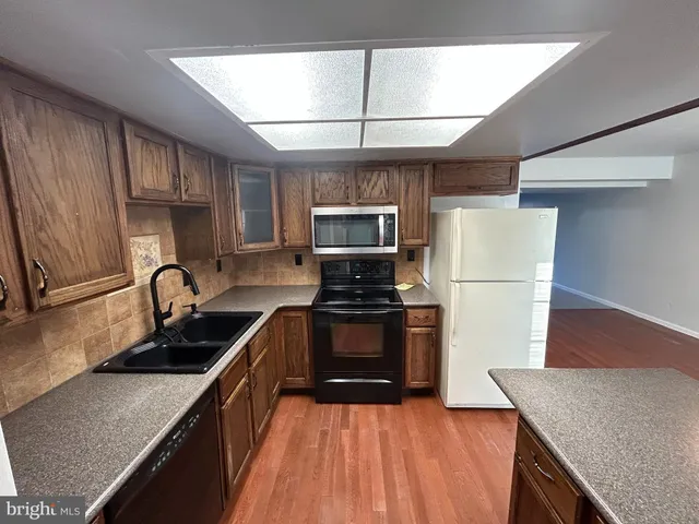 a kitchen with granite countertop a stove a refrigerator and a sink