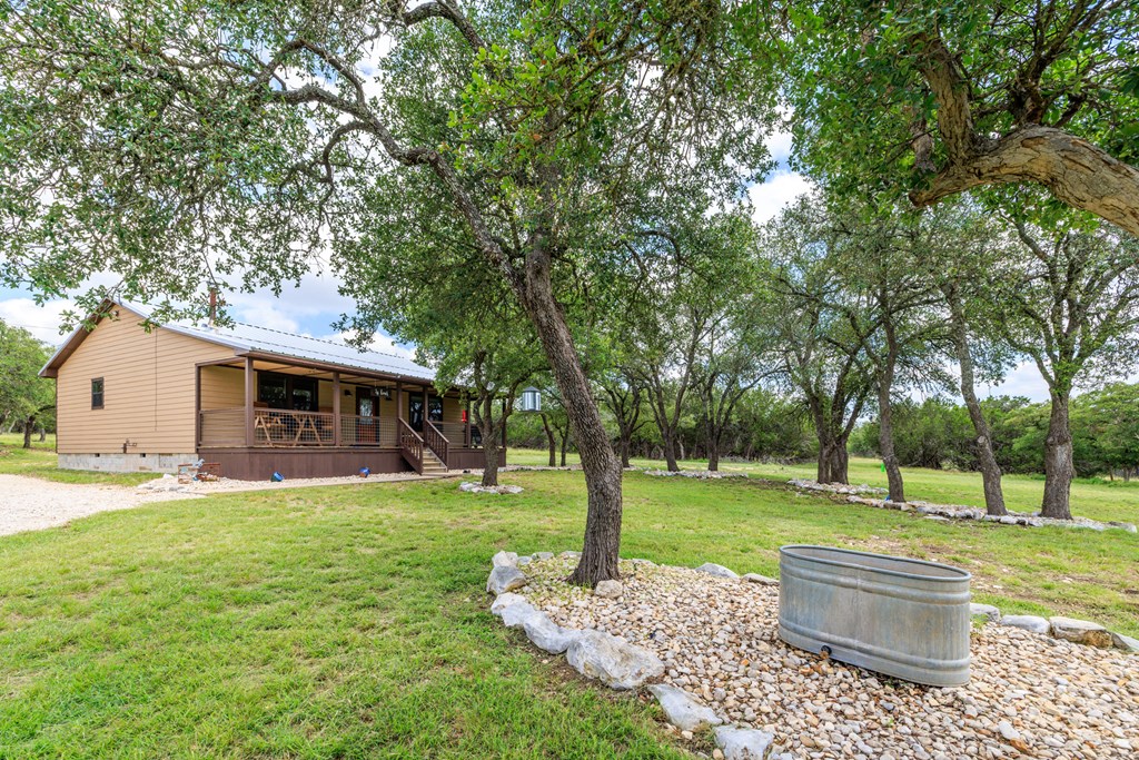 221 Coyote Trail Harper, TX 78631 - Photo 16 of 47 a front view of a house with garden