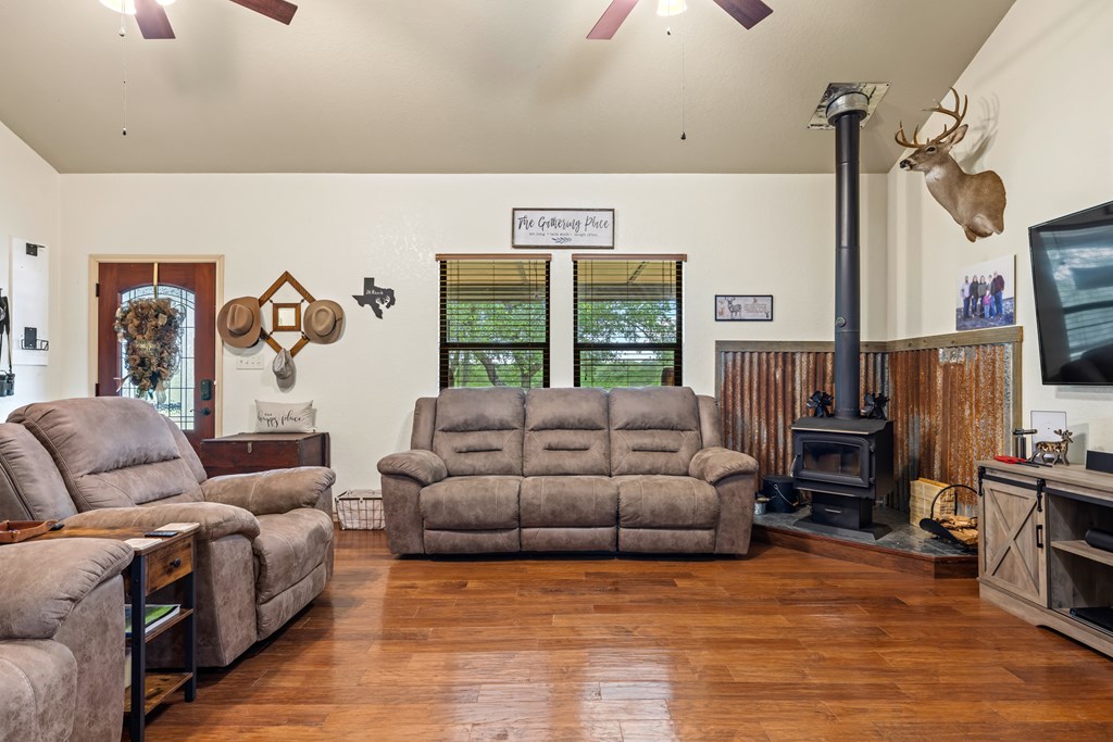 221 Coyote Trail Harper, TX 78631 - Photo 2 of 47 a living room with furniture a flat screen tv and a fireplace