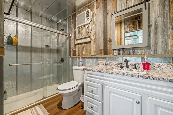 a bathroom with a granite countertop sink toilet and shower